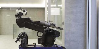 A robotic arm mounted on a tracked base in a modern workspace