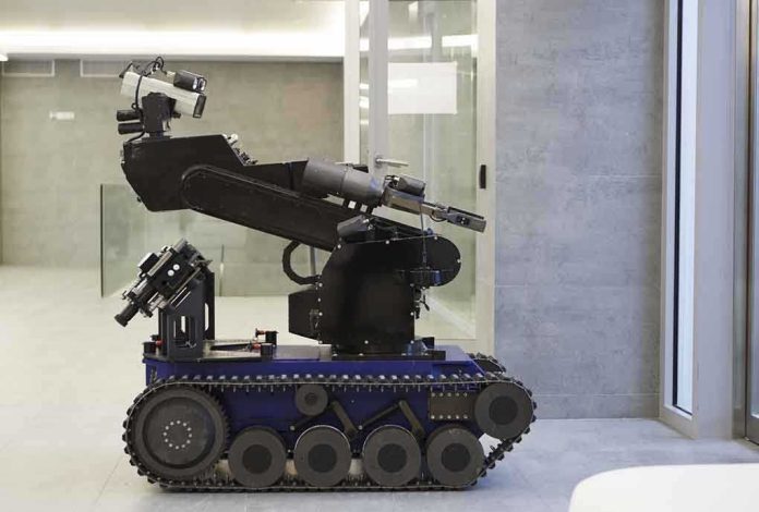 shutterstock_68039032.jpg A robotic arm mounted on a tracked base in a modern workspace