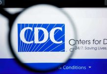 Shocking CDC Vaccine Cut: Experts Fear Disaster CDC logo magnified on a screen.