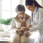 Shocking Gene Discovery in Super-Agers Doctor showing phone to a smiling elderly woman.