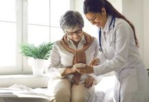 Doctor showing phone to a smiling elderly woman.