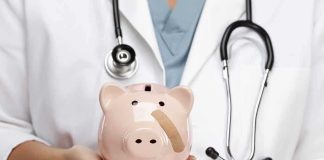 A doctor in a white coat holding a piggy bank with a bandage on it