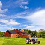Trump Saves American Farms- $12 Billion SURPRISE A vintage tractor in front of a red barn on a sunny day