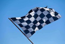 Trump UNLEASHES IndyCar Racing Through National Mall A checkered flag waving against a clear blue sky