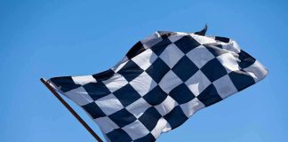Trump UNLEASHES IndyCar Racing Through National Mall A checkered flag waving against a clear blue sky