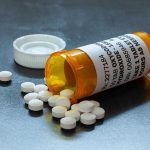 Pain Patients Branded Addicts—The Hidden Truth Open pill bottle with white tablets spilled out.