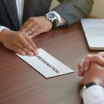 Epstein Network Shakes Hospitality Giant Handing in a resignation letter across a table.