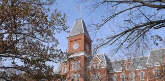 Historic university building with students walking in front during autumn