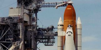 Astronauts SHATTER 54-Year Record—Into the Void Space shuttle on launch pad with support structure.