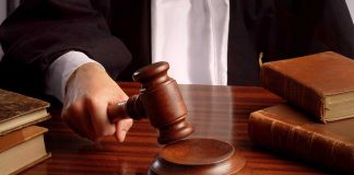 158-Year Ban Overturned: Home Distilling Legal A judges hand holding a gavel over a wooden desk with law books