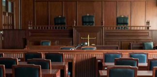 Empty courtroom with wooden furnishings and judges bench.