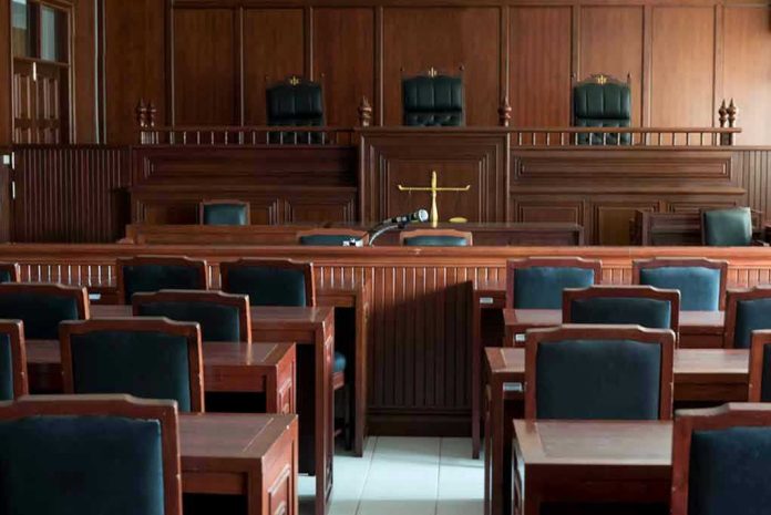 1154521519-1 Empty courtroom with wooden furnishings and judges bench.