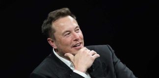 Musk’s AI Lawsuit Dismissed – Is OpenAI’s True Nature Exposed? Man in suit smiling, resting chin on hand.