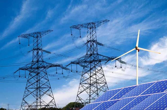 shutterstock_138865700 Solar panels and a wind turbine with power lines against a blue sky