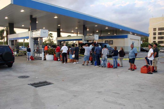 shutterstock_4189537 People waiting in line at a gas station with fuel containers