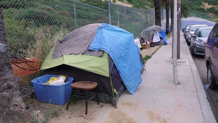 1392494762 Tents and belongings set up along sidewalk.