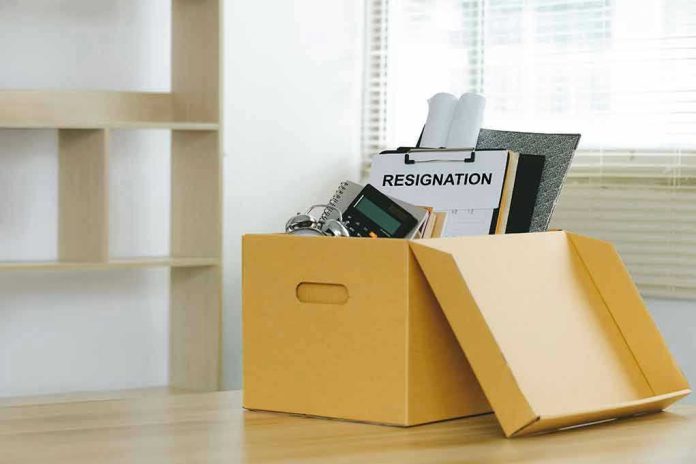 2170196715 Yellow box with resignation notice on an office desk.