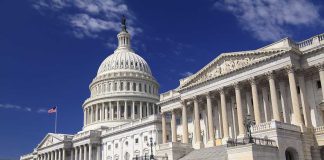 Surveillance Power Teeters — What’s Congress Hiding? The U.S. Capitol building with its dome and columns under a blue sky