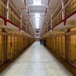 Gun Grab Turns Prison Into Warzone Long hallway with prison cells on both sides.