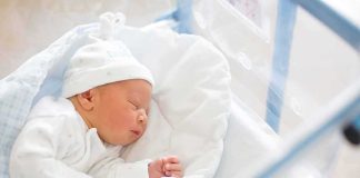 Historic Baby Shakes D.C. Norms Newborn baby sleeping in hospital bassinet
