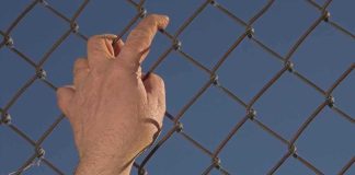 Border Meltdown in Spain’s Ceuta Hand gripping a chain-link fence