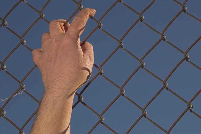 shutterstock_10213060 Hand gripping a chain-link fence