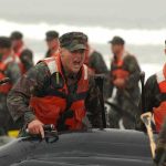 Island Search Intensifies — Timeline Chaos Soldiers in life vests haul an inflatable boat from the surf