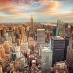 Tax-the-Rich Backfires? $10B Gone Aerial view of New York City skyline during sunset with skyscrapers and clouds