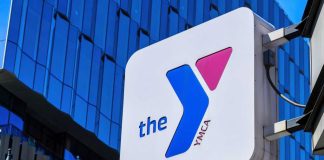 Girls’ Spaces Fight Explodes At YMCA YMCA sign mounted on a modern glass building