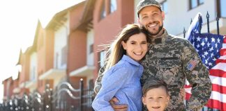 Military family posing together outside a suburban home