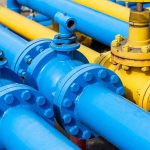 Blue and yellow industrial pipelines with valves and flanges