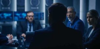 Online Rant Triggers Lightning FBI Bust Business team in a dim conference room