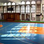 Top Groups Go Silent on Fair Play Indoor basketball court with blue floor and orange key areas