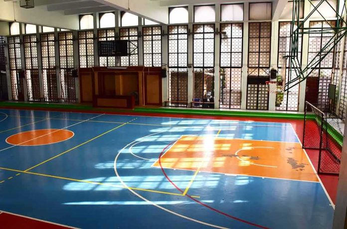 Indoor basketball court with blue floor and orange key areas
