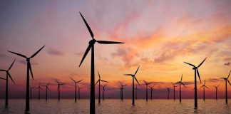 Offshore wind turbines at sunset over calm sea