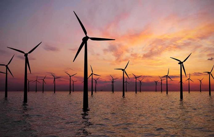 shutterstock_1454940068 Offshore wind turbines at sunset over calm sea