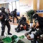 Terror Label Hits Cartel—$25M Up For Grabs Tactical police detain suspects in an office lobby