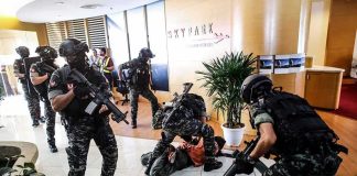 Tactical police detain suspects in an office lobby