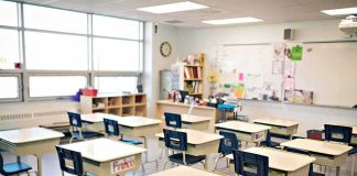 Teacher Of The Year Walks—Grades Quietly Flipped Empty classroom with rows of student desks and chairs