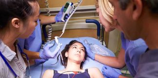 Anchor’s Heart Scare Ignites Vaccine Firestorm Patient on hospital gurney surrounded by medical staff