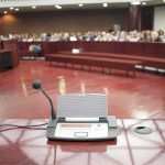 Fauci Showdown: Contempt Vote Ignites DOJ Gamble Conference microphone on a podium in a courtroom