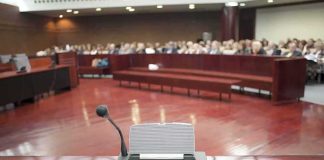 Fauci Showdown: Contempt Vote Ignites DOJ Gamble Conference microphone on a podium in a courtroom