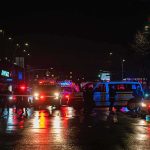 Homeless Burglar Demands $10M Payout Nighttime police scene with flashing lights on a wet city street