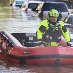 White River Shatters 1913 Record Rescue worker in an inflatable boat during urban flooding
