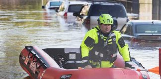 White River Shatters 1913 Record Rescue worker in an inflatable boat during urban flooding