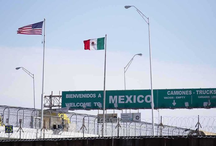 shutterstock_2236173447 Border crossing with U.S. and Mexico flags and a sign welcoming to Mexico