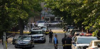 Arson Arrest Ignites Fury In Spokane Police officers secure a residential street with patrol cars and yellow tape
