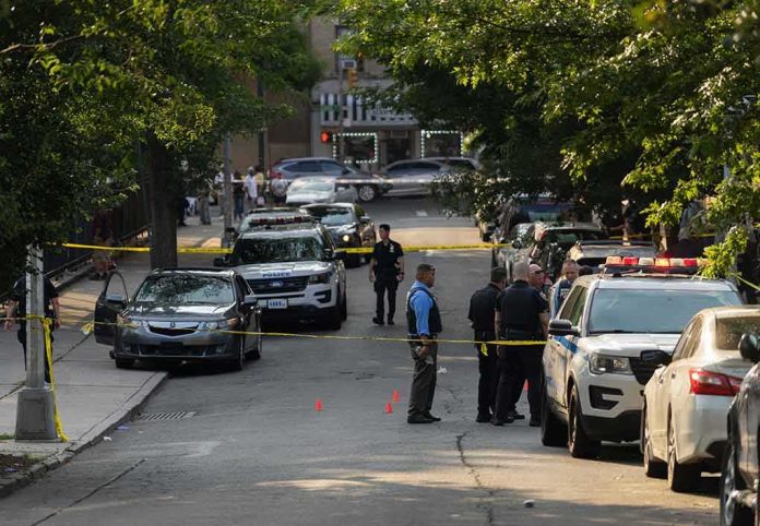 shutterstock_2330301305-2 Police officers secure a residential street with patrol cars and yellow tape
