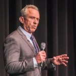 Rubio Mocks RFK Jr.: ‘Cooler Of Kraut?’ man in a suit speaking into a microphone on stage