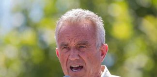 man speaking into a microphone outdoors